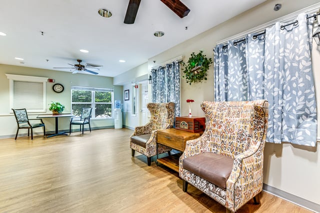 Seating with blue curtains and arm chairs